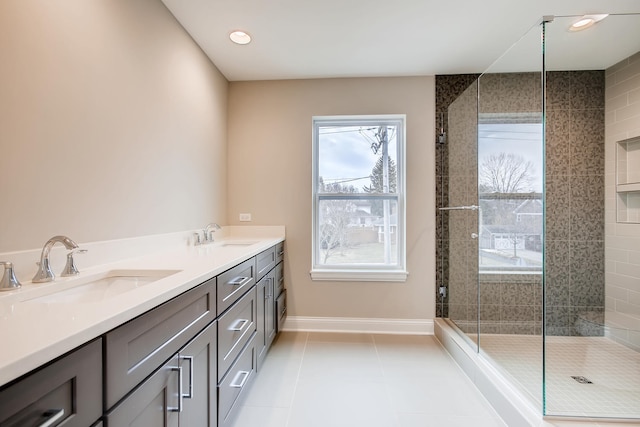 bathroom featuring walk in shower, double vanity, a healthy amount of sunlight, and tile flooring