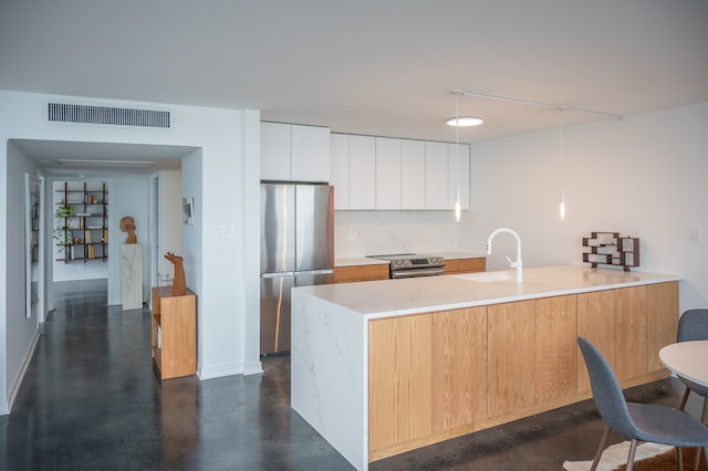 kitchen with stainless steel appliances, light stone countertops, white cabinets, hanging light fixtures, and sink