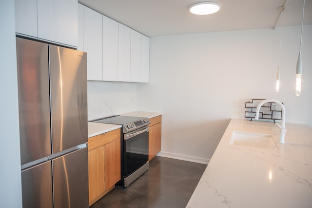 kitchen with light stone counters, white cabinetry, stainless steel appliances, sink, and hanging light fixtures