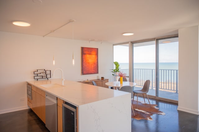 kitchen with a water view, wine cooler, sink, light stone countertops, and rail lighting