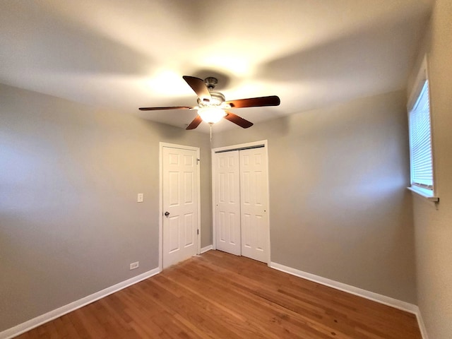 unfurnished bedroom featuring ceiling fan and dark hardwood / wood-style flooring