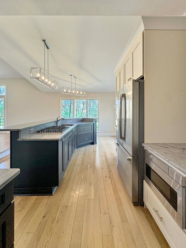 kitchen featuring white cabinetry, a wealth of natural light, stainless steel appliances, and light hardwood / wood-style flooring