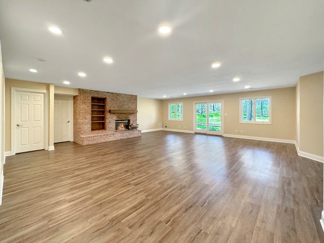 unfurnished living room featuring a fireplace and light hardwood / wood-style floors