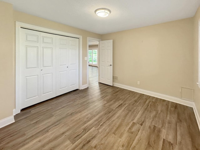 unfurnished bedroom featuring hardwood / wood-style flooring and a closet