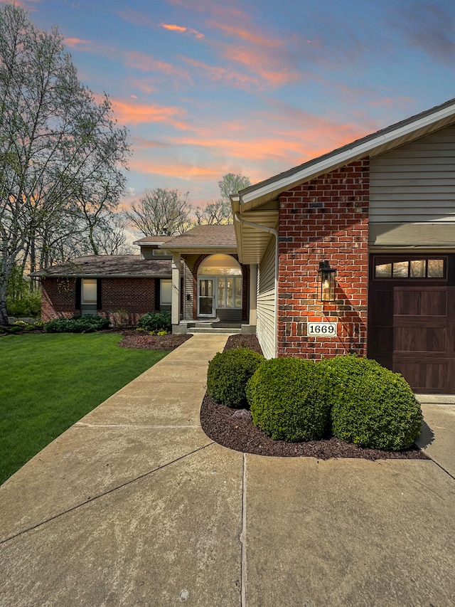 view of front of house featuring a lawn and a garage