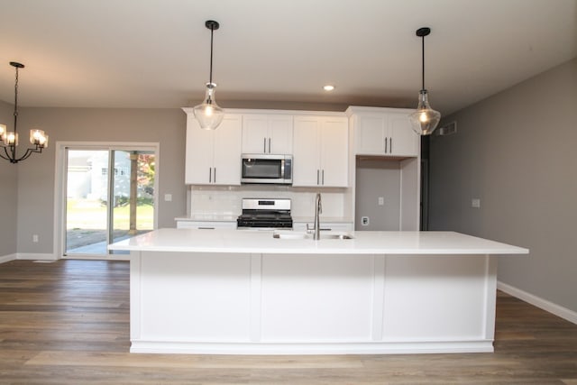 kitchen featuring tasteful backsplash, white cabinetry, appliances with stainless steel finishes, sink, and an inviting chandelier