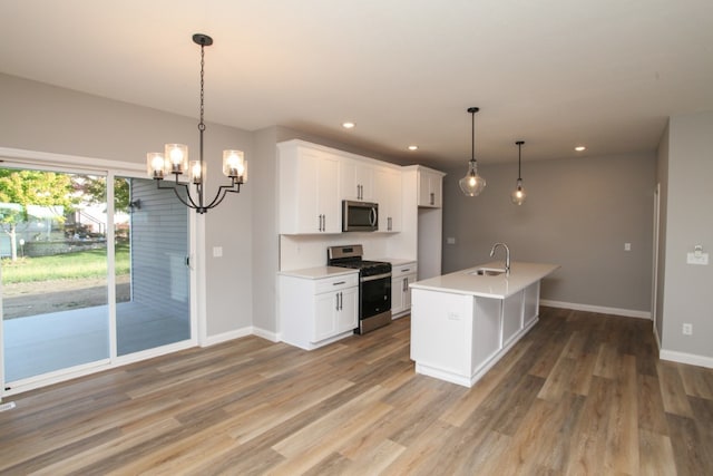 kitchen featuring hardwood / wood-style flooring, pendant lighting, a notable chandelier, and appliances with stainless steel finishes