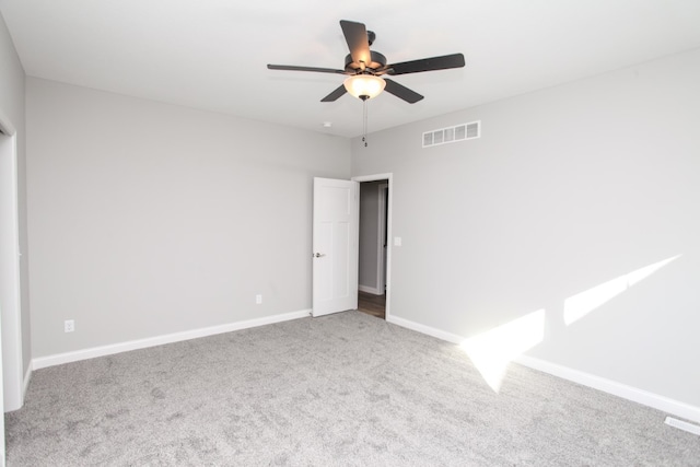 empty room with ceiling fan and light carpet