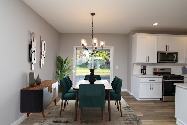 dining space with a chandelier and light hardwood / wood-style flooring