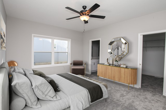 carpeted bedroom with ensuite bath, a spacious closet, a closet, and ceiling fan