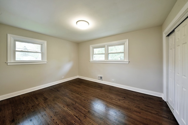 unfurnished bedroom featuring a closet and dark hardwood / wood-style floors