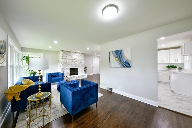 living room featuring hardwood / wood-style floors and a stone fireplace