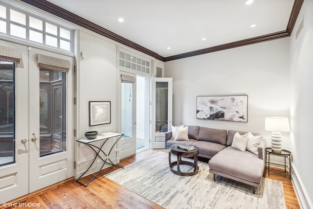 sitting room with light hardwood / wood-style floors, french doors, and ornamental molding