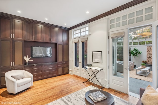 interior space with ornamental molding, light hardwood / wood-style flooring, and french doors