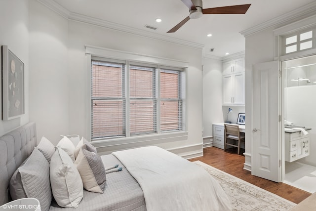 bedroom with ensuite bathroom, dark hardwood / wood-style flooring, ceiling fan, and multiple windows