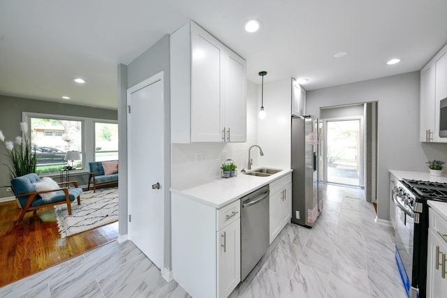 kitchen with white cabinetry, hanging light fixtures, sink, stainless steel appliances, and light tile floors