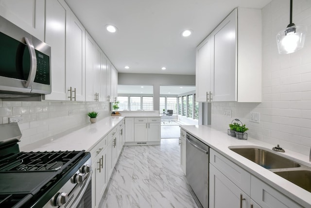 kitchen with pendant lighting, stainless steel appliances, light tile floors, tasteful backsplash, and white cabinets