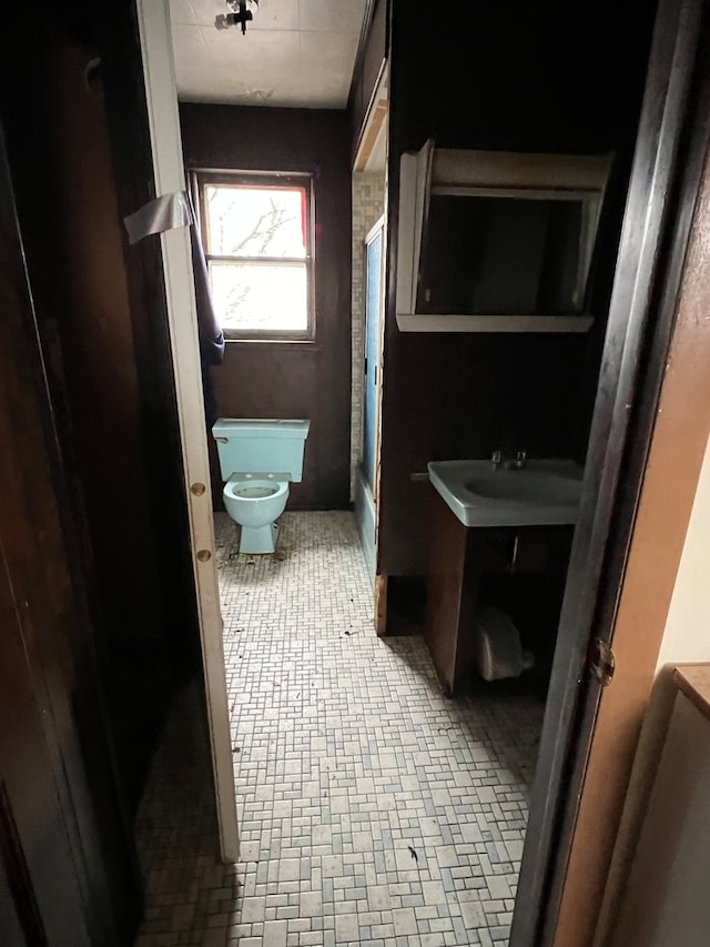 bathroom with toilet, tile floors, and vanity