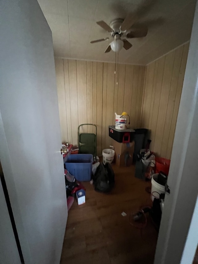 miscellaneous room featuring ceiling fan and wood walls