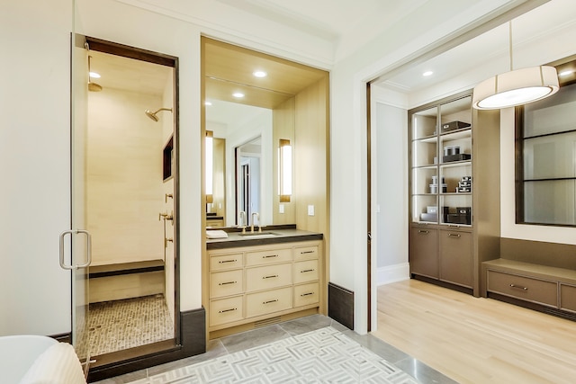 bathroom with walk in shower, hardwood / wood-style flooring, and oversized vanity