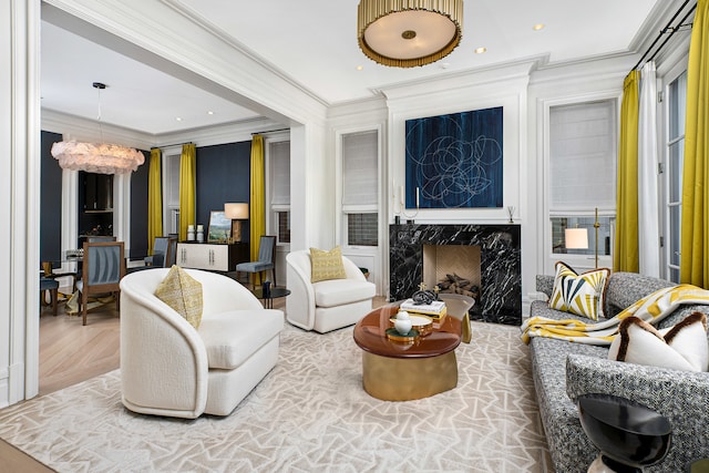 living area featuring crown molding, an inviting chandelier, a fireplace, and parquet floors