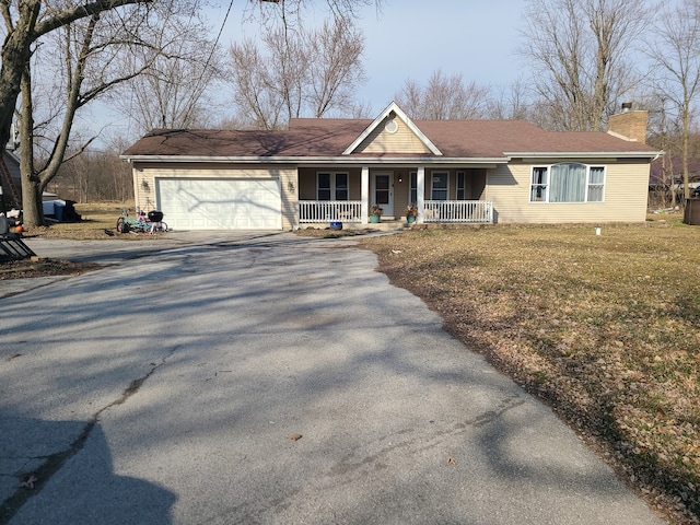 ranch-style home with a front yard, a porch, and a garage