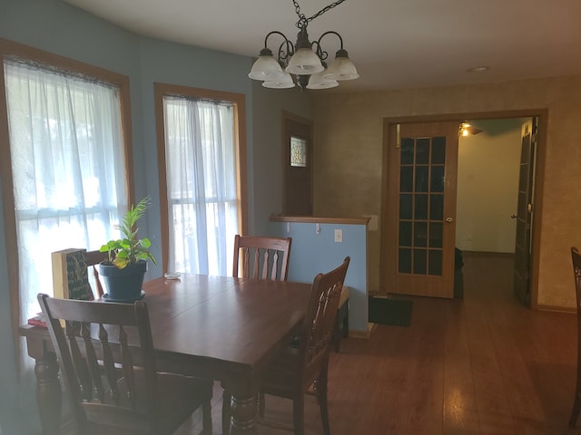 dining space with a chandelier and dark hardwood / wood-style flooring