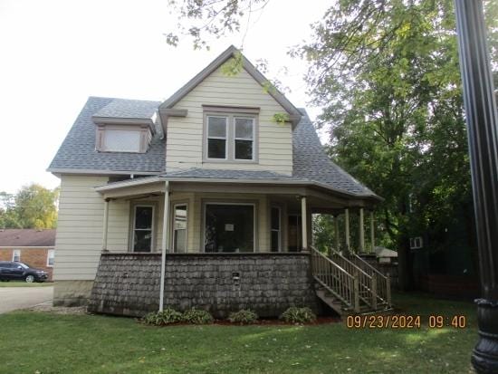 view of front of property with covered porch and a front lawn