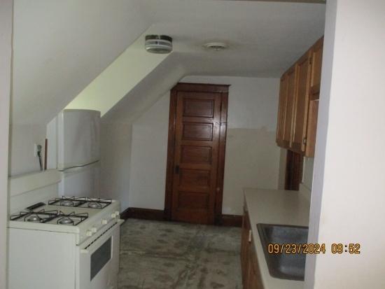 kitchen featuring white appliances, sink, and vaulted ceiling