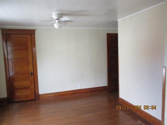 unfurnished room with dark hardwood / wood-style flooring and ceiling fan