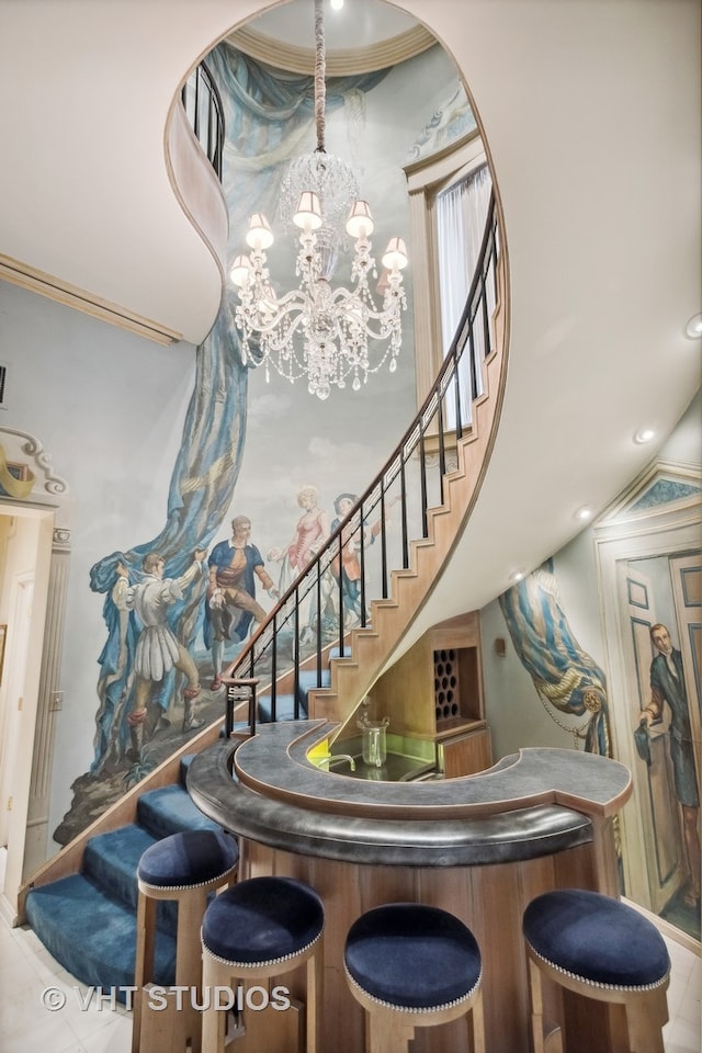 stairs with a notable chandelier and vaulted ceiling