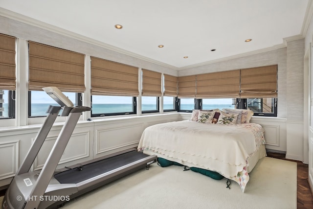 bedroom featuring crown molding, a water view, dark parquet floors, and multiple windows