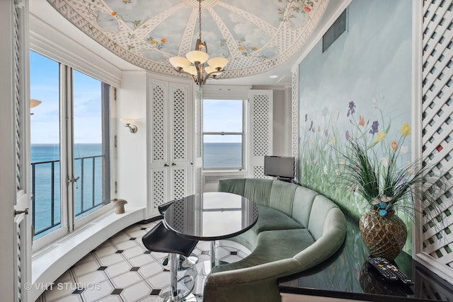 interior space featuring a water view, ornamental molding, and a chandelier