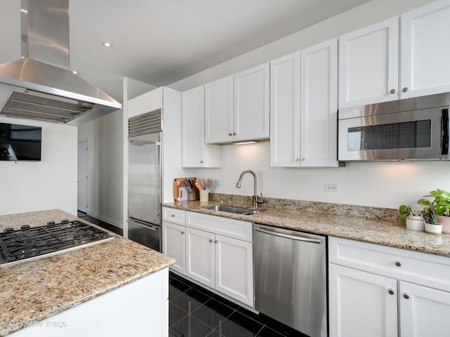 kitchen with stainless steel appliances, white cabinetry, extractor fan, and dark tile floors