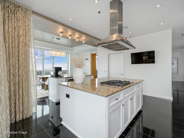 kitchen featuring island range hood, a center island, white cabinetry, and dark tile flooring