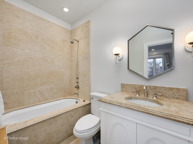 full bathroom with toilet, tiled shower / bath combo, and vanity