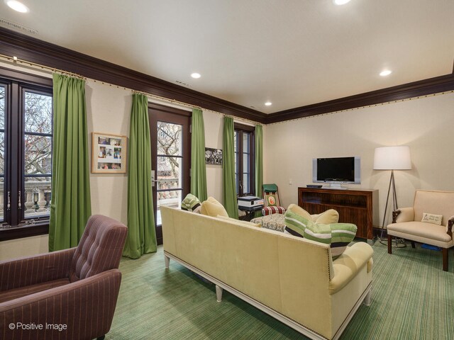 living room with carpet floors, crown molding, and a healthy amount of sunlight