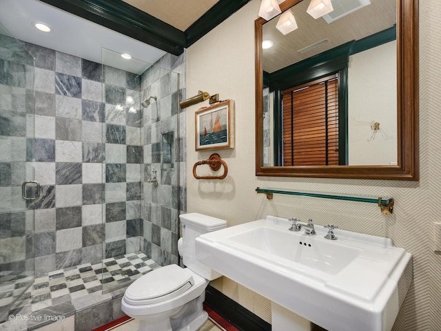 bathroom featuring sink, toilet, and a shower with door