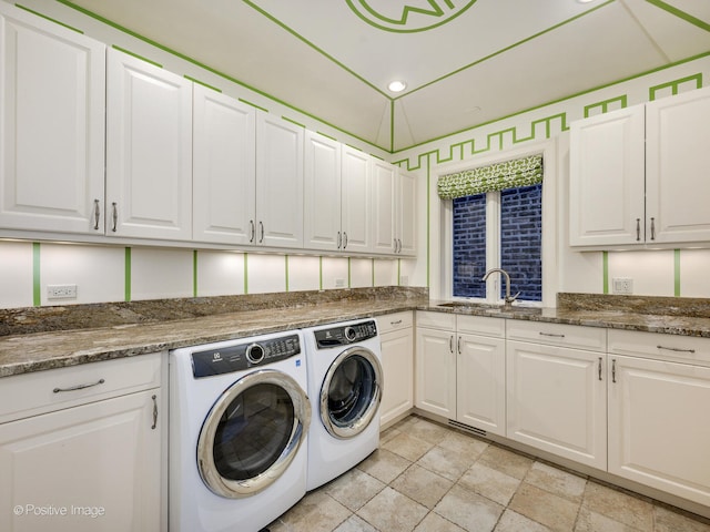 laundry area featuring light tile patterned floors, washing machine and dryer, sink, and cabinets