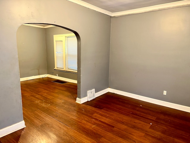 spare room with crown molding and dark wood-type flooring