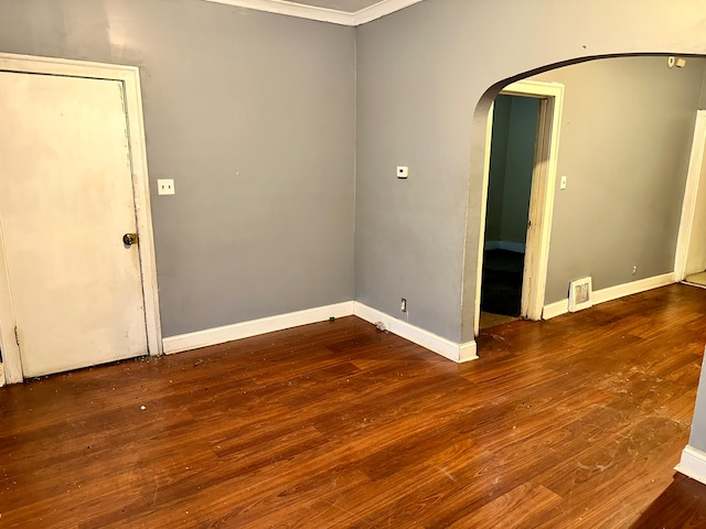 spare room with ornamental molding and dark hardwood / wood-style floors