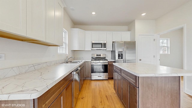 laundry area with baseboards, laundry area, washer hookup, and light wood-type flooring