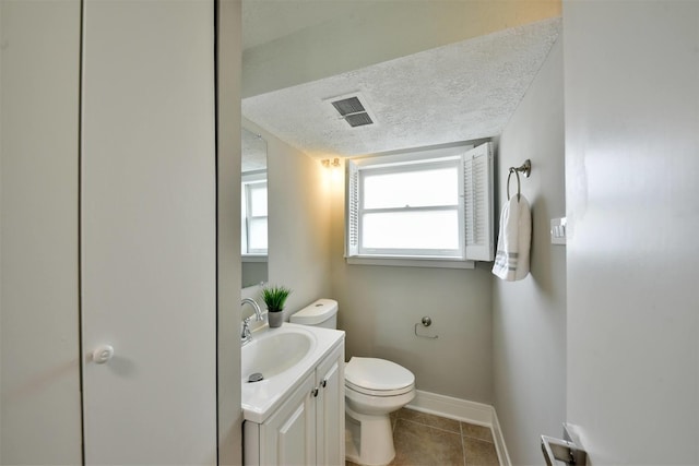 bathroom with toilet, tile flooring, a textured ceiling, and vanity