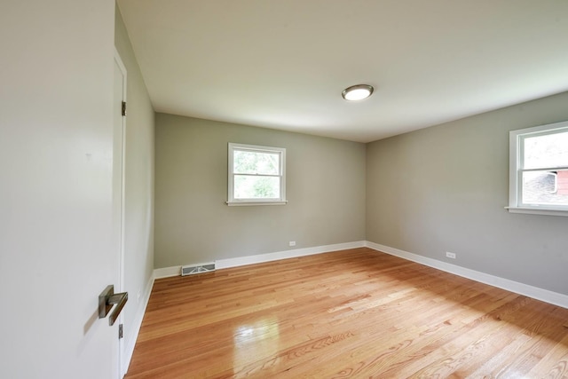 unfurnished room with a healthy amount of sunlight and light hardwood / wood-style flooring