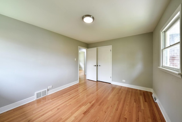 spare room featuring light wood-type flooring and a healthy amount of sunlight