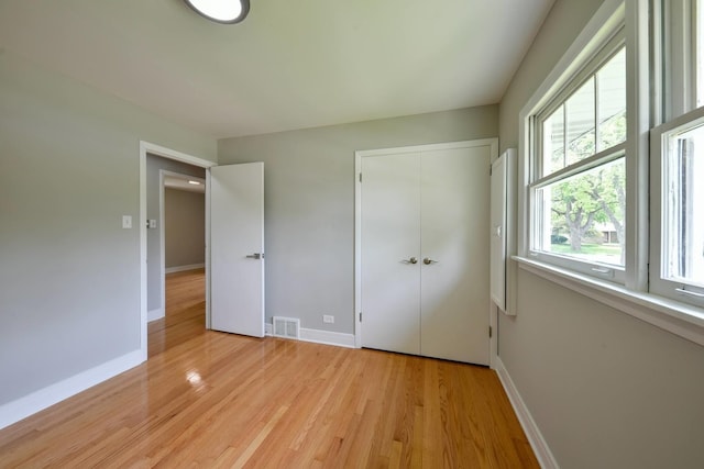 unfurnished bedroom featuring a closet and light wood-type flooring