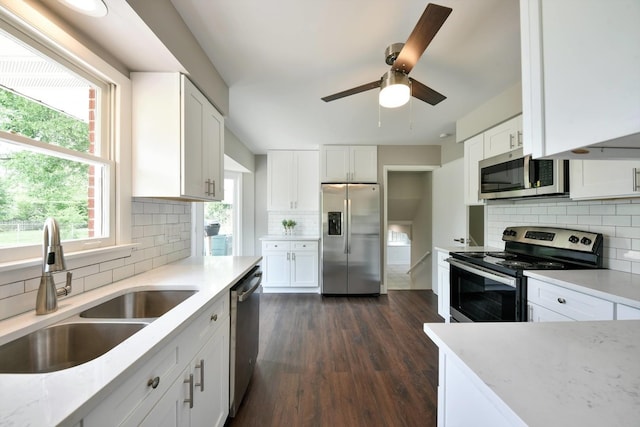 kitchen with white cabinets, backsplash, stainless steel appliances, and dark wood-type flooring