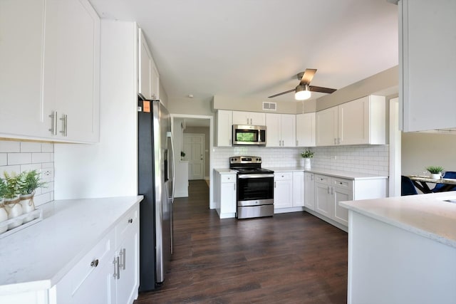 kitchen with ceiling fan, stainless steel appliances, backsplash, dark hardwood / wood-style flooring, and white cabinetry