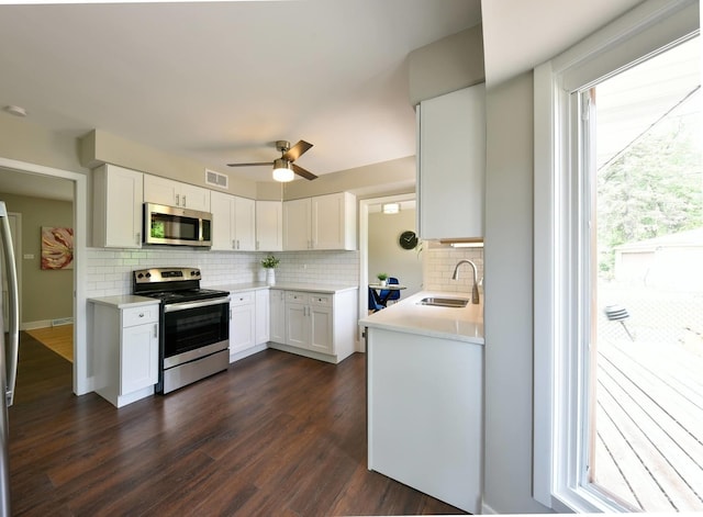 kitchen featuring ceiling fan, sink, stainless steel appliances, white cabinets, and dark hardwood / wood-style flooring