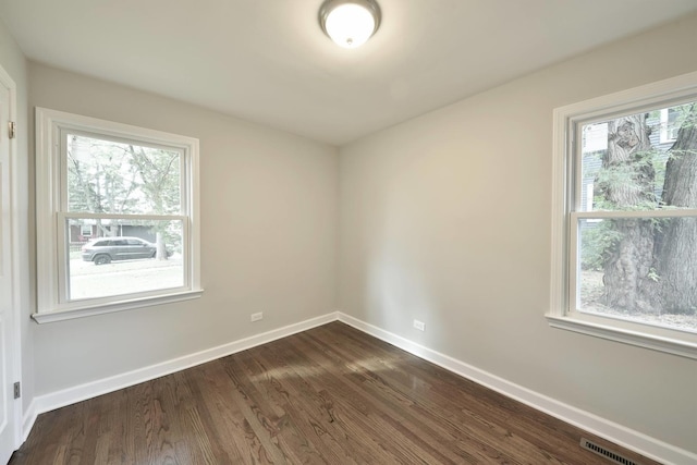 unfurnished room with dark hardwood / wood-style floors and a wealth of natural light